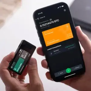 Blockstream jade Plus in Schwarz in der Hand neben der Blockstream Green App